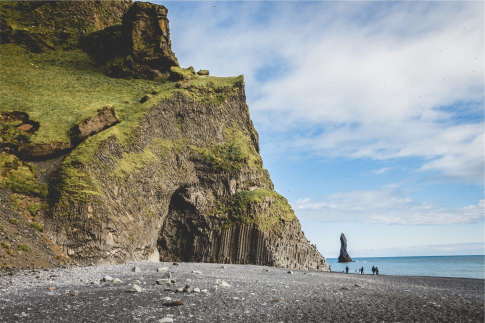 Free Image of Scenic coastal cliff with basalt columns and people in the distance 