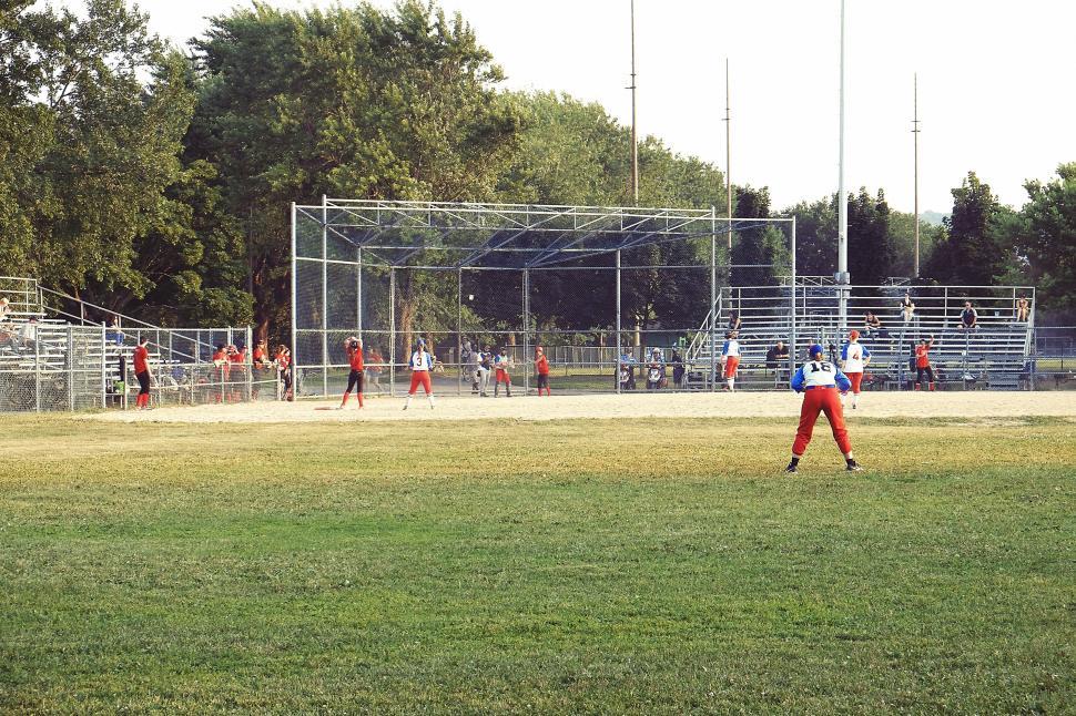 Free Image of Outdoor baseball game with players in uniforms, field, and spectators. 