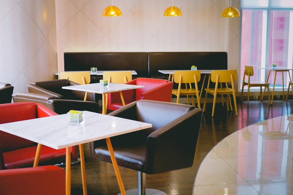 Free Image of Modern cafe interior with colorful chairs and stylish decor 