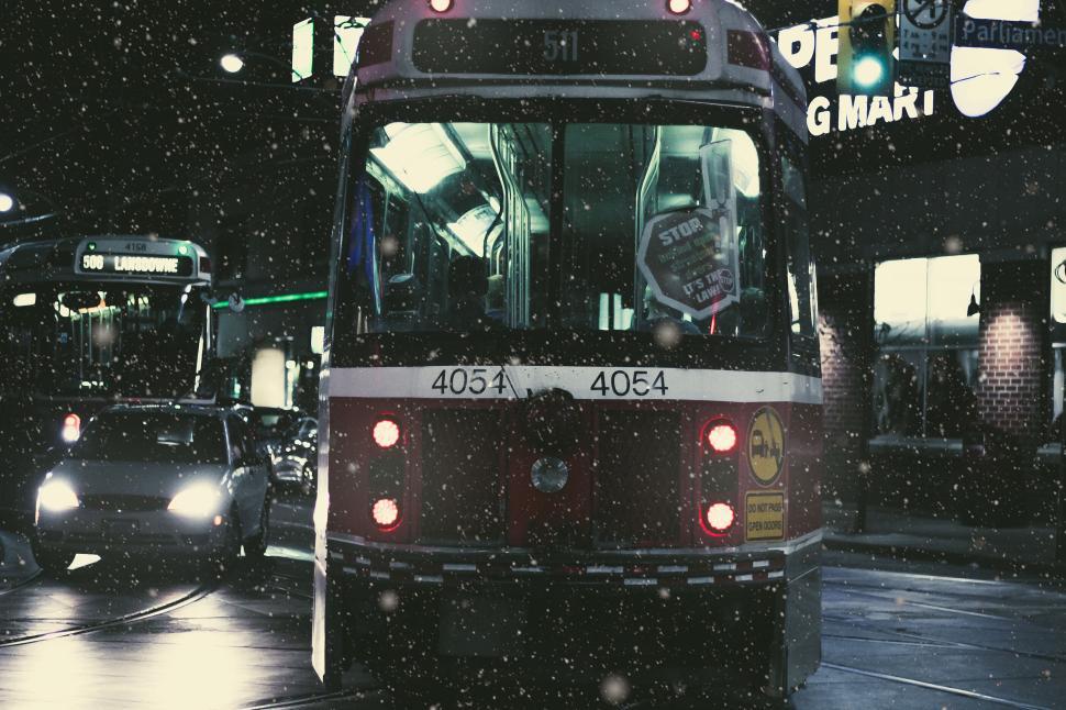 Free Image of Night view of a bustling tram in snowfall with glowing city lights. 