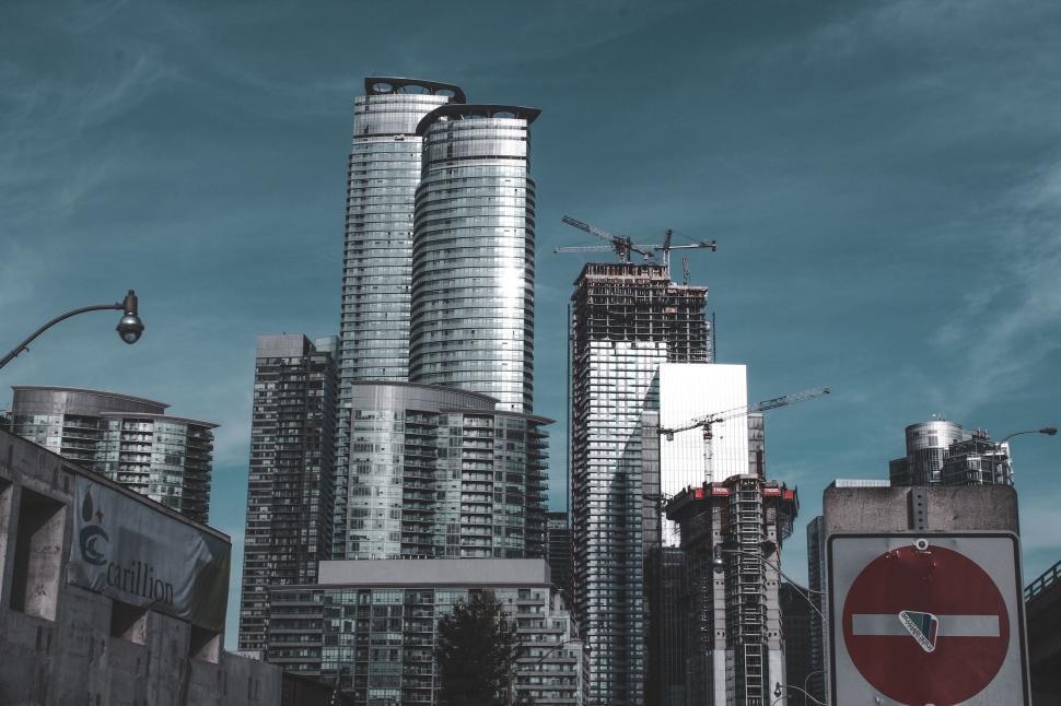 Free Image of Skyline of modern skyscrapers under construction with cranes visible. 