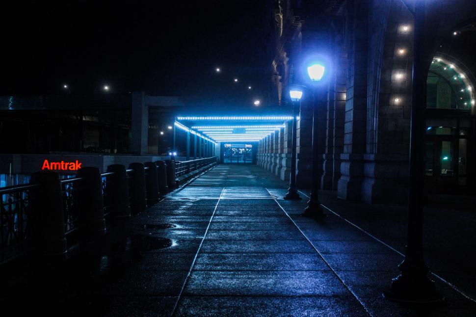 Free Image of Nighttime corridor with blue lights and Amtrak sign in the distance. 