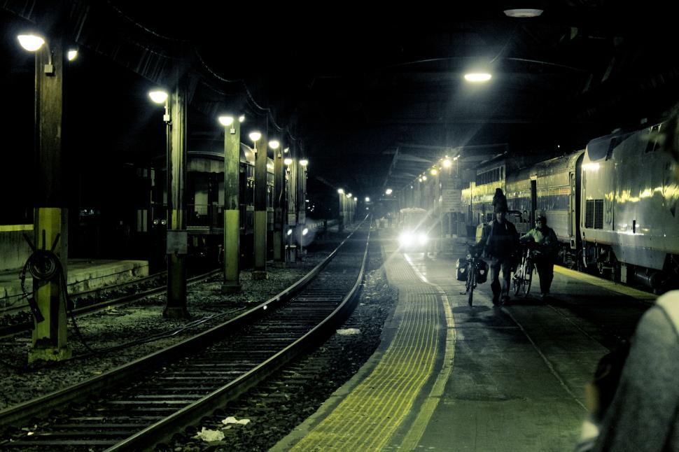Free Image of Train platform at night with dim lighting and a boarding train. 