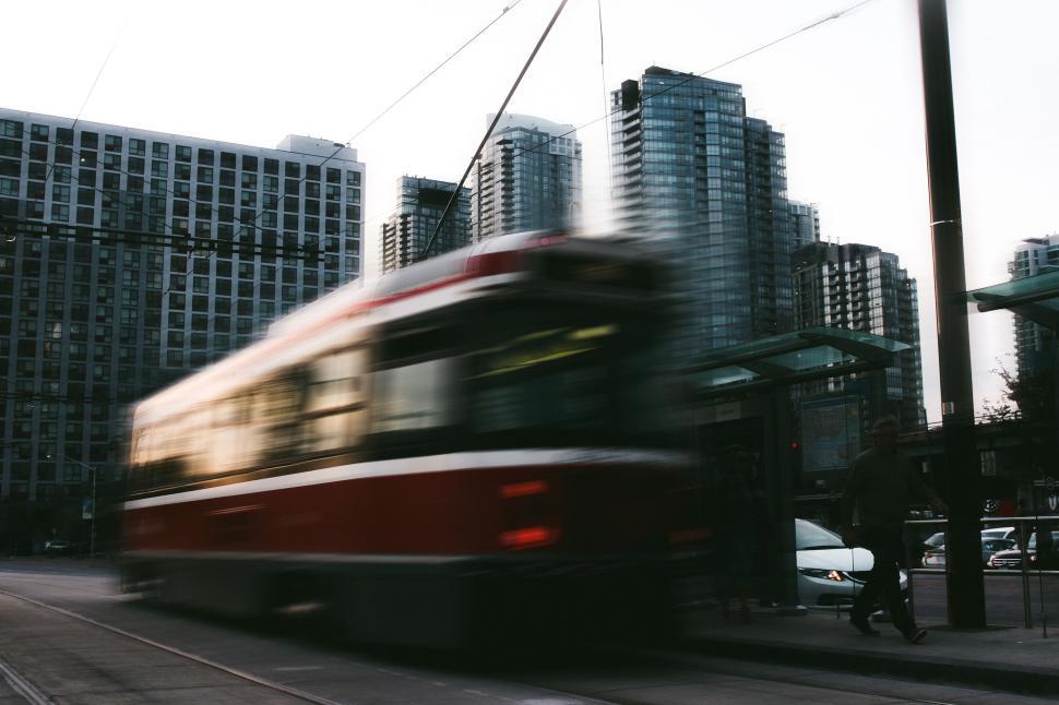 Free Image of Modern city tram in motion with tall buildings in the background. 