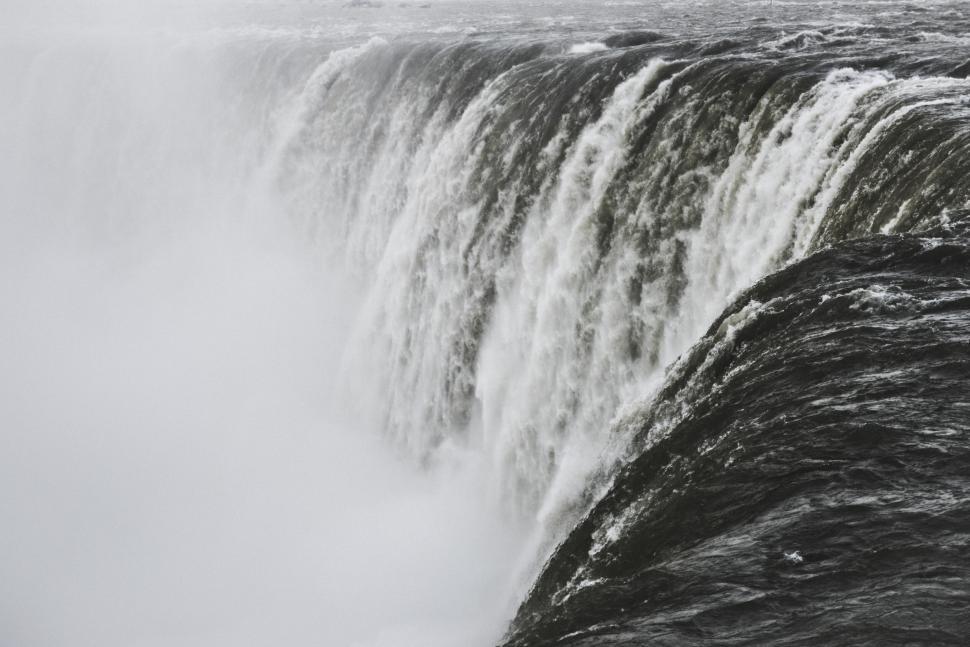 Free Image of Mighty waterfall with mist rising in the air from powerful descent 