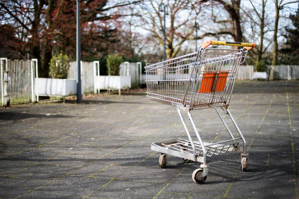 Free Image of Empty shopping cart left outside in a deserted parking lot. 