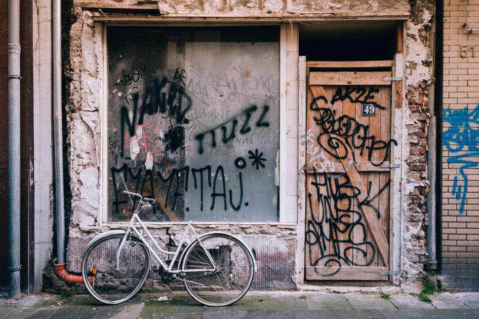 Free Image of Graffiti-covered storefront with a white bicycle parked in front 