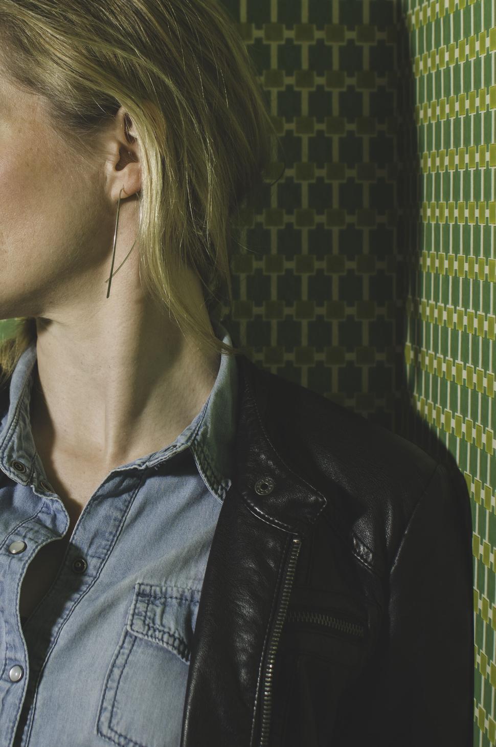 Free Image of Portrait of a woman in a stylish leather jacket and dangling earring. 