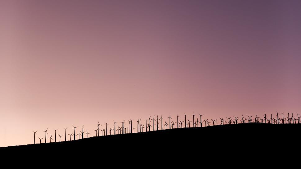 Free Image of Silhouette of wind turbines on a hill during stunning twilight sky 