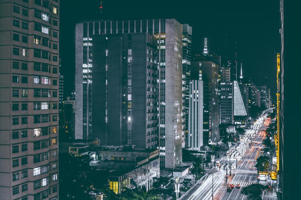 Free Image of Night cityscape with high-rise buildings and car light trails. 