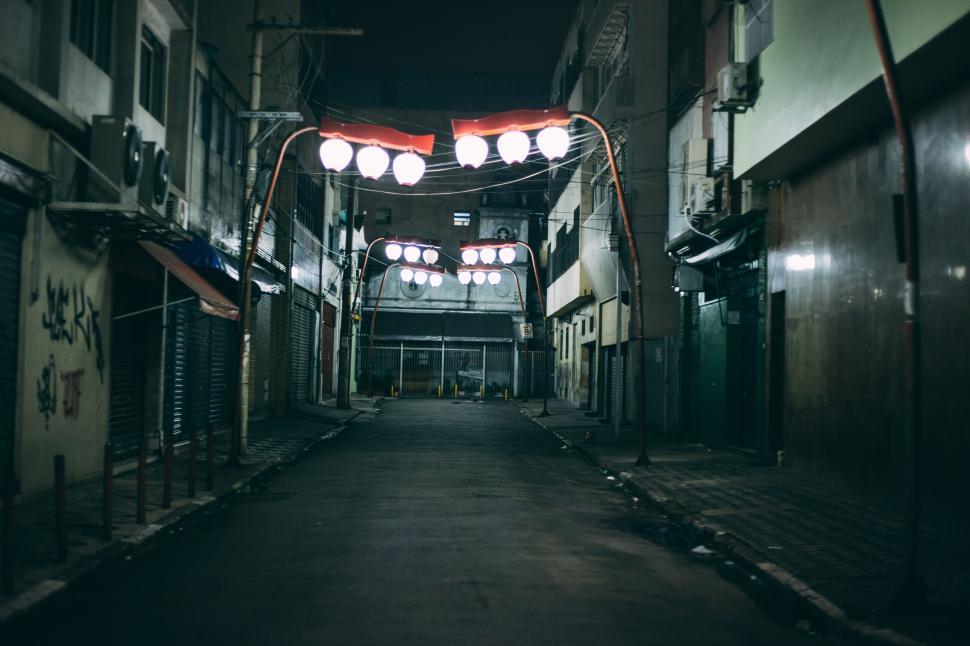 Free Image of Deserted street at night with hanging lanterns in urban setting. 