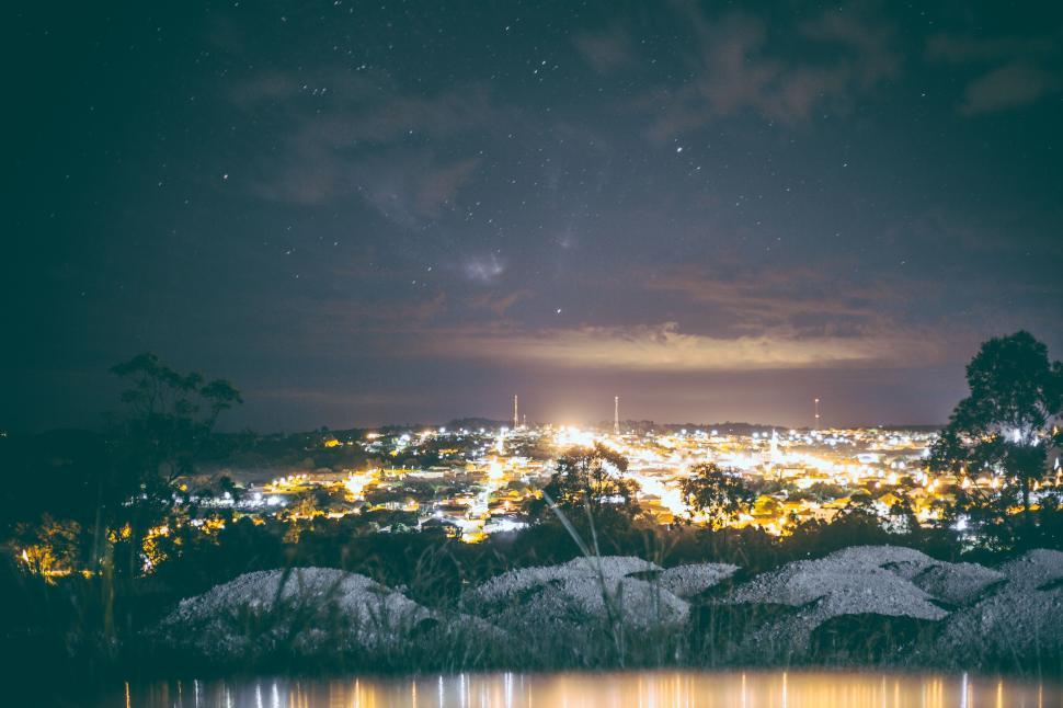 Free Image of Cityscape night view with sparkling lights under a starry sky. 