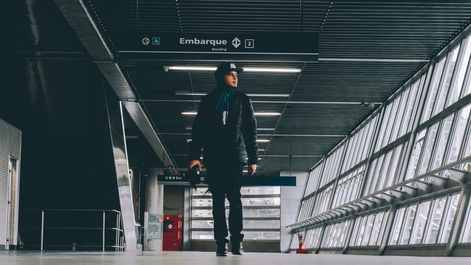 Free Image of Traveler walking through airport terminal to boarding gate 