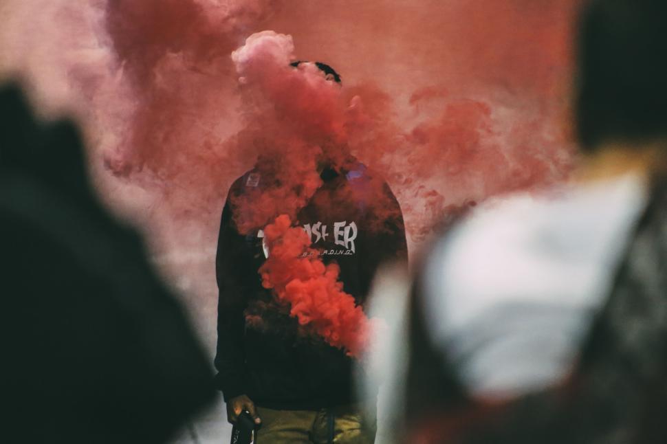 Free Image of Person holding red smoke flare with dramatic background effect 
