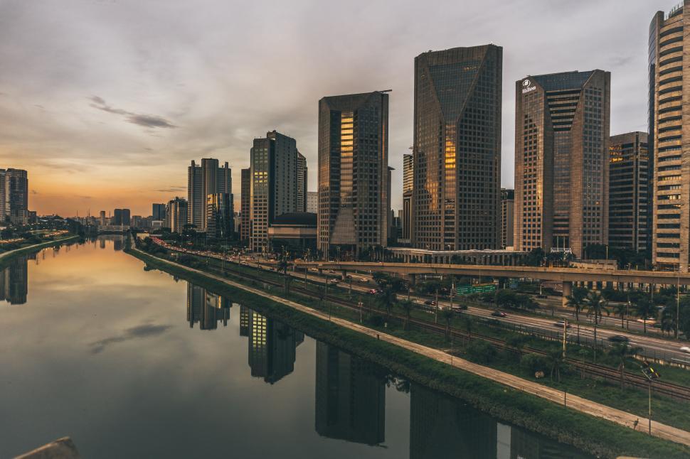 Free Image of Skyline of modern city buildings reflecting in calm river waters. 
