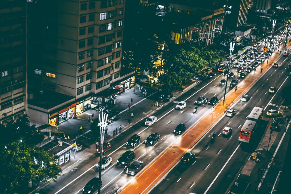 Free Image of Busy city street illuminated at night with cars and pedestrians. 