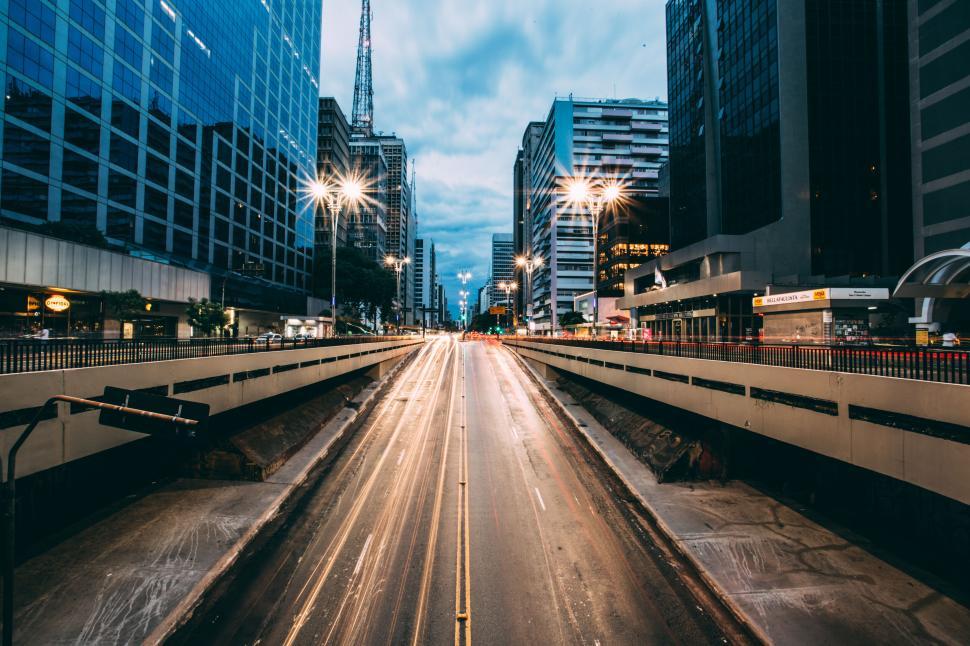 Free Image of Bustling city street with skyscrapers, lights and motion blur. 