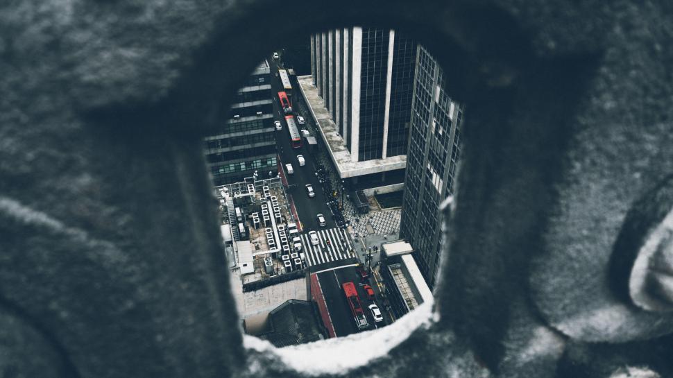 Free Image of Aerial view of city street through a concrete structure aperture. 