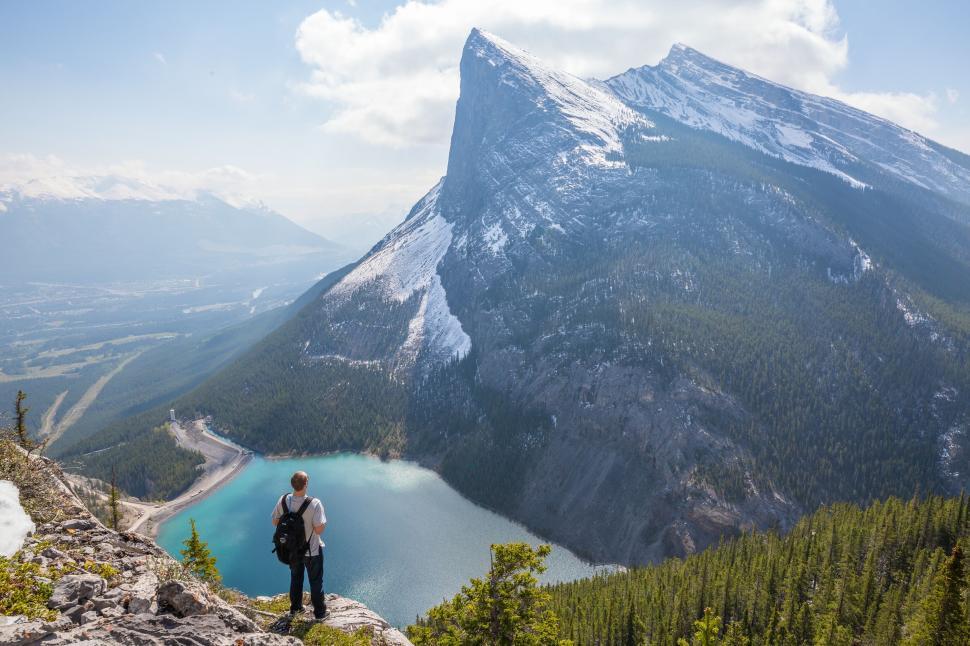 Free Image of Hiker admiring the view of lake and mountain from scenic vista 
