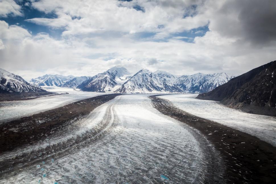 Free Image of Winding glacier cutting through a rugged, mountainous landscape. 