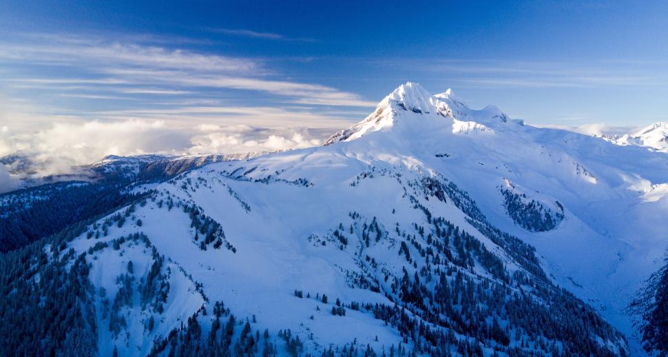 Free Image of Snow-covered mountains under a crisp, clear blue winter sky 