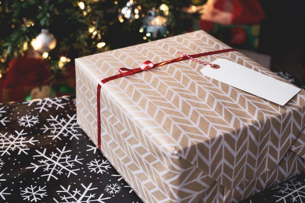Free Image of Wrapped Christmas presents with festive lights in the background. 