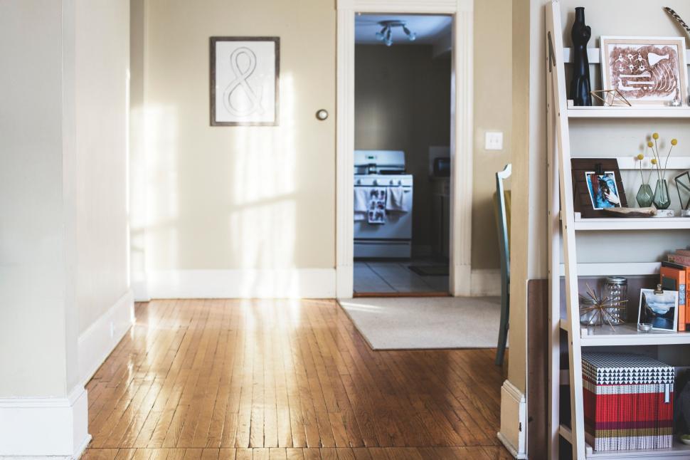 Free Image of Bright hallway with wooden floors and a glimpse into a kitchen. 