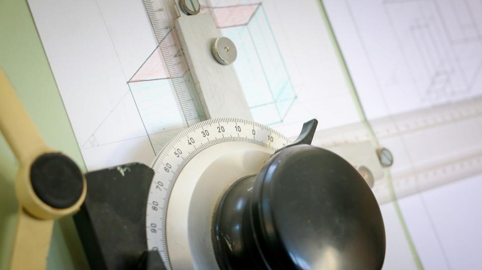 Free Image of Close-up of a drafting machine with a technical drawing on a table 