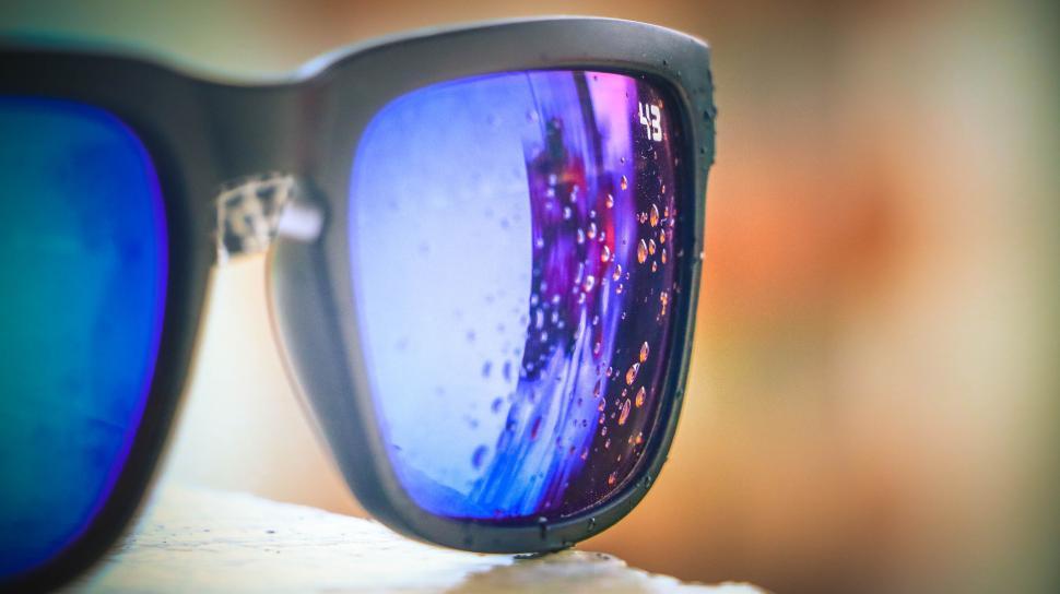 Free Image of Close-up of stylish sunglasses with raindrops on the reflective lenses 