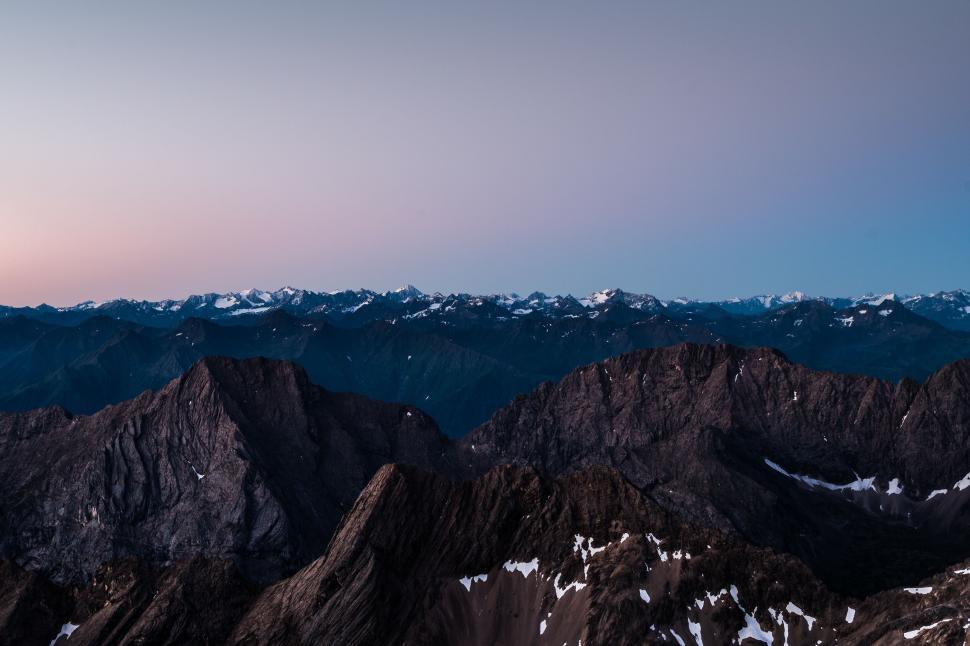 Free Image of Rugged mountain peaks under a twilight sky, majestic and wild 