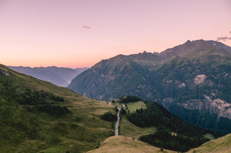 Free Image of Road meandering through lush green hills toward distant mountains. 