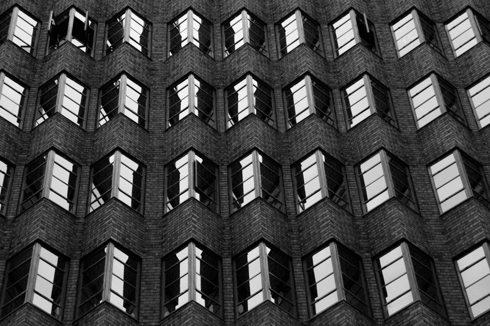 Free Image of Architectural building facade with repetitive pattern and open windows. 