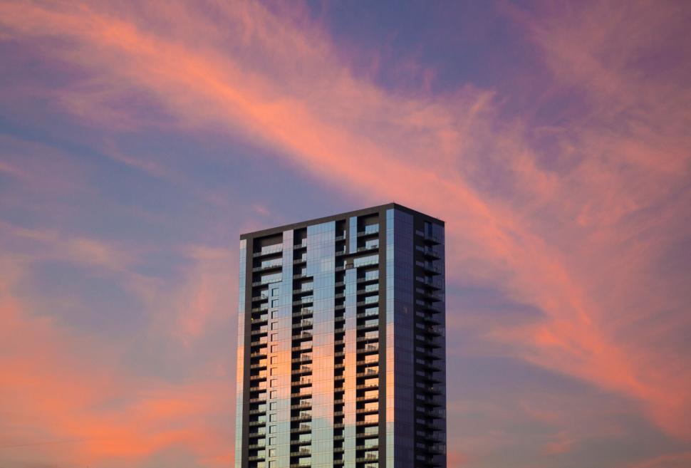 Free Image of Tall modern building against vibrant colorful sunset sky view. 