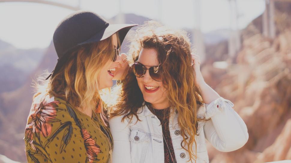 Free Image of Two friends sharing a tender moment against a scenic backdrop. 
