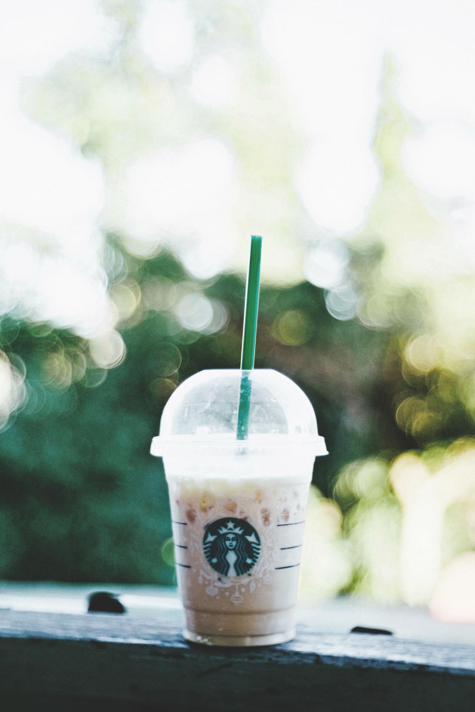 Free Image of Cold beverage in plastic cup placed outdoors with blurred background 