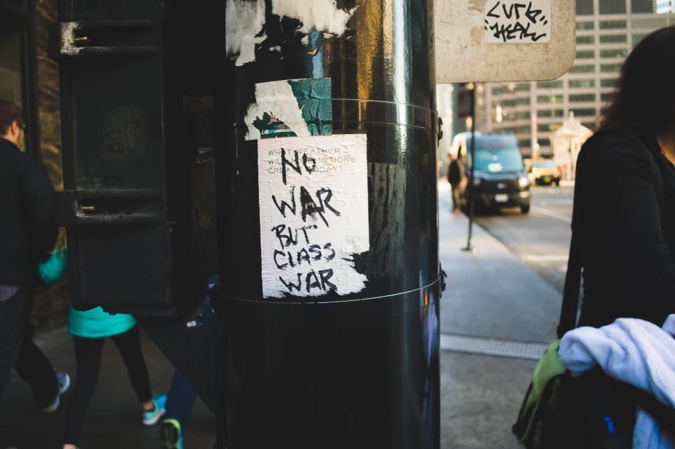 Free Image of Graffiti on urban pole with people in background walking by 