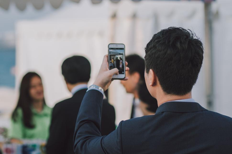 Free Image of Person taking photo at outdoor event or gathering, focusing on crowd. 
