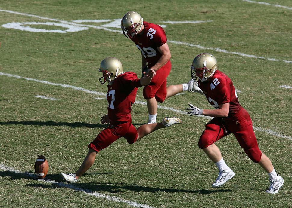 Free Image of Action shot of football players in mid-play on a grassy field. 