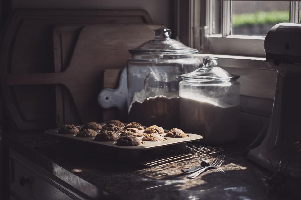 Free Image of Freshly baked cookies cooling on kitchen countertop near window 