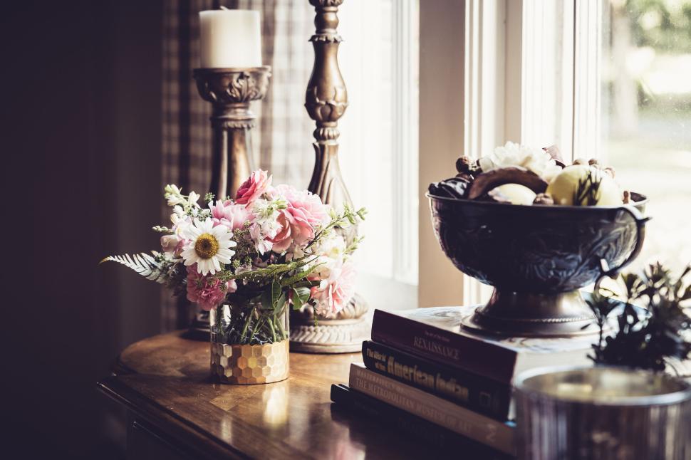 Free Image of Elegant flower vase on a wooden table in a cozy, sunlit room 