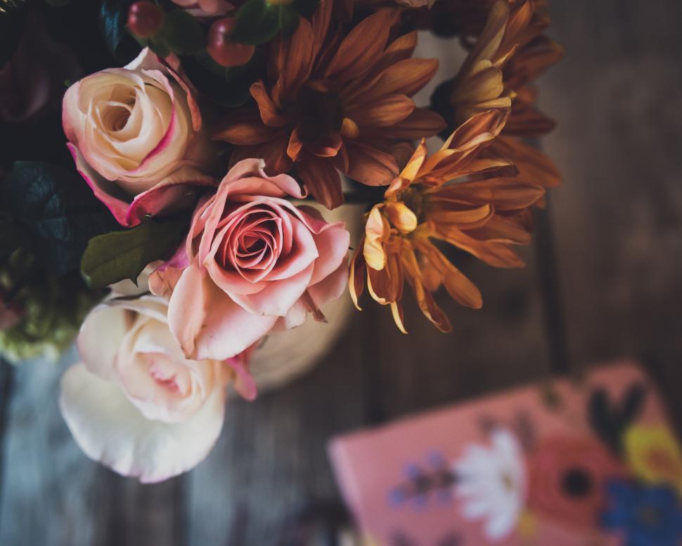 Free Image of Elegant bouquet of pastel roses and orange mums in soft lighting 