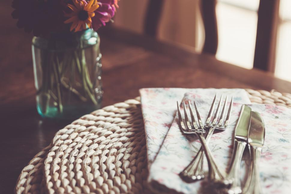 Free Image of Elegant table with floral napkins and silver cutlery arranged neatly 
