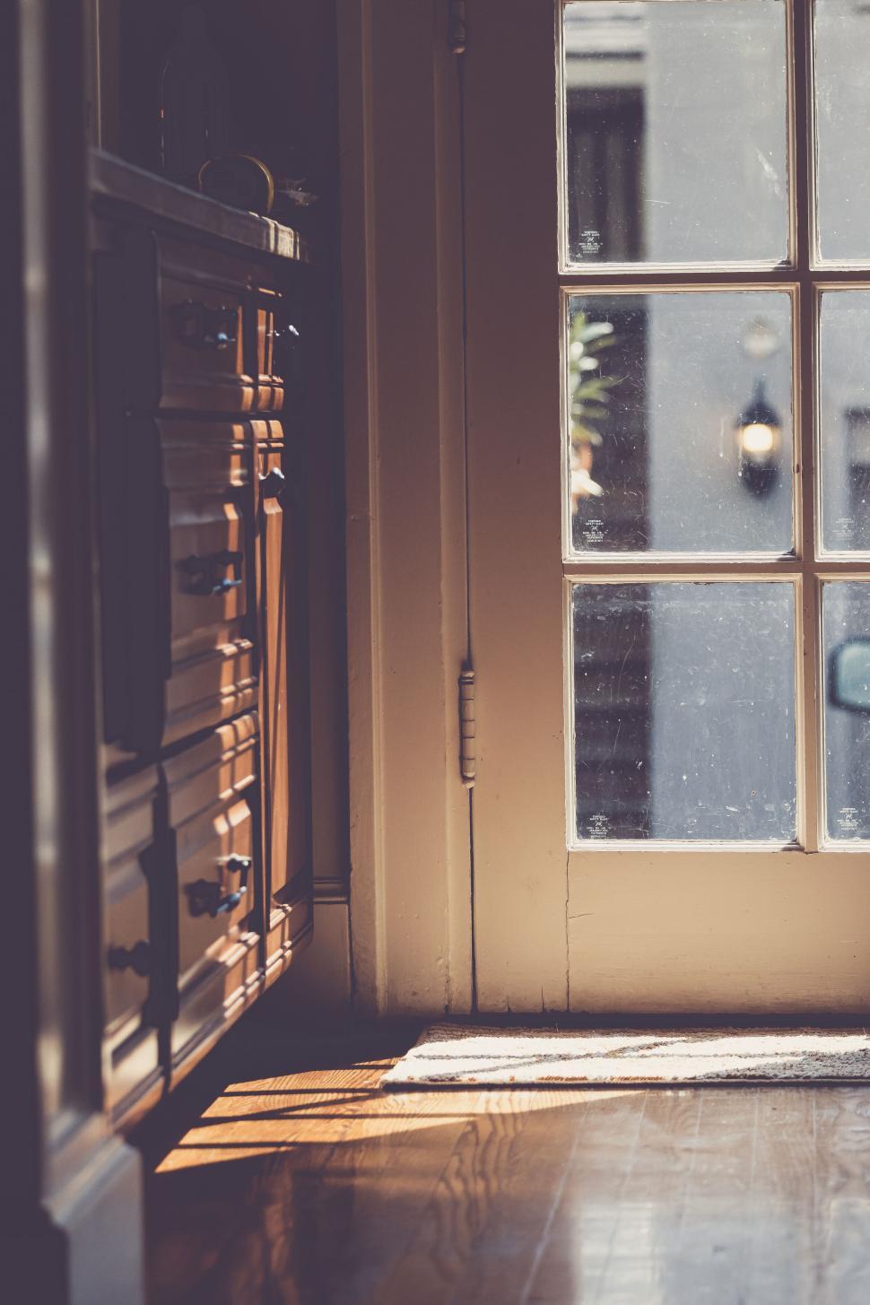 Free Image of Warm sunlight streaming through a doorway inside a cozy home 