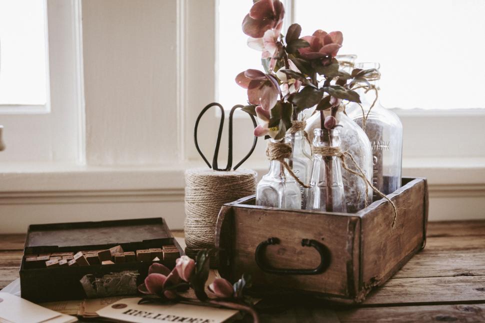 Free Image of Rustic wooden box with vintage bottles and twine on windowsill. 