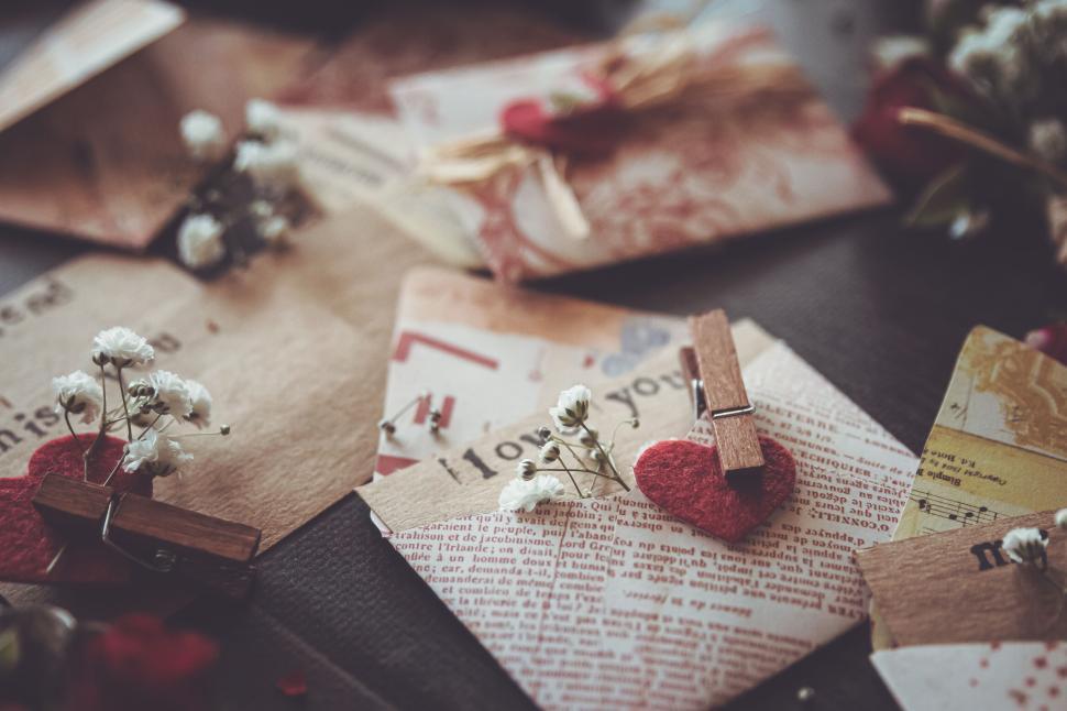 Free Image of Vintage-styled assorted letters and cards with tiny white flowers 