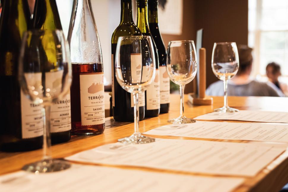 Free Image of Selection of wines and empty wine glasses on a wooden counter 