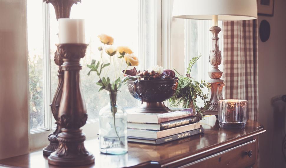 Free Image of Rustic interior table with candles, books, and decorations 