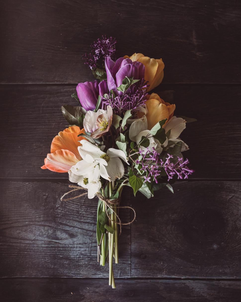 Free Image of Vibrant bouquet with purple, orange, white flowers on dark background 