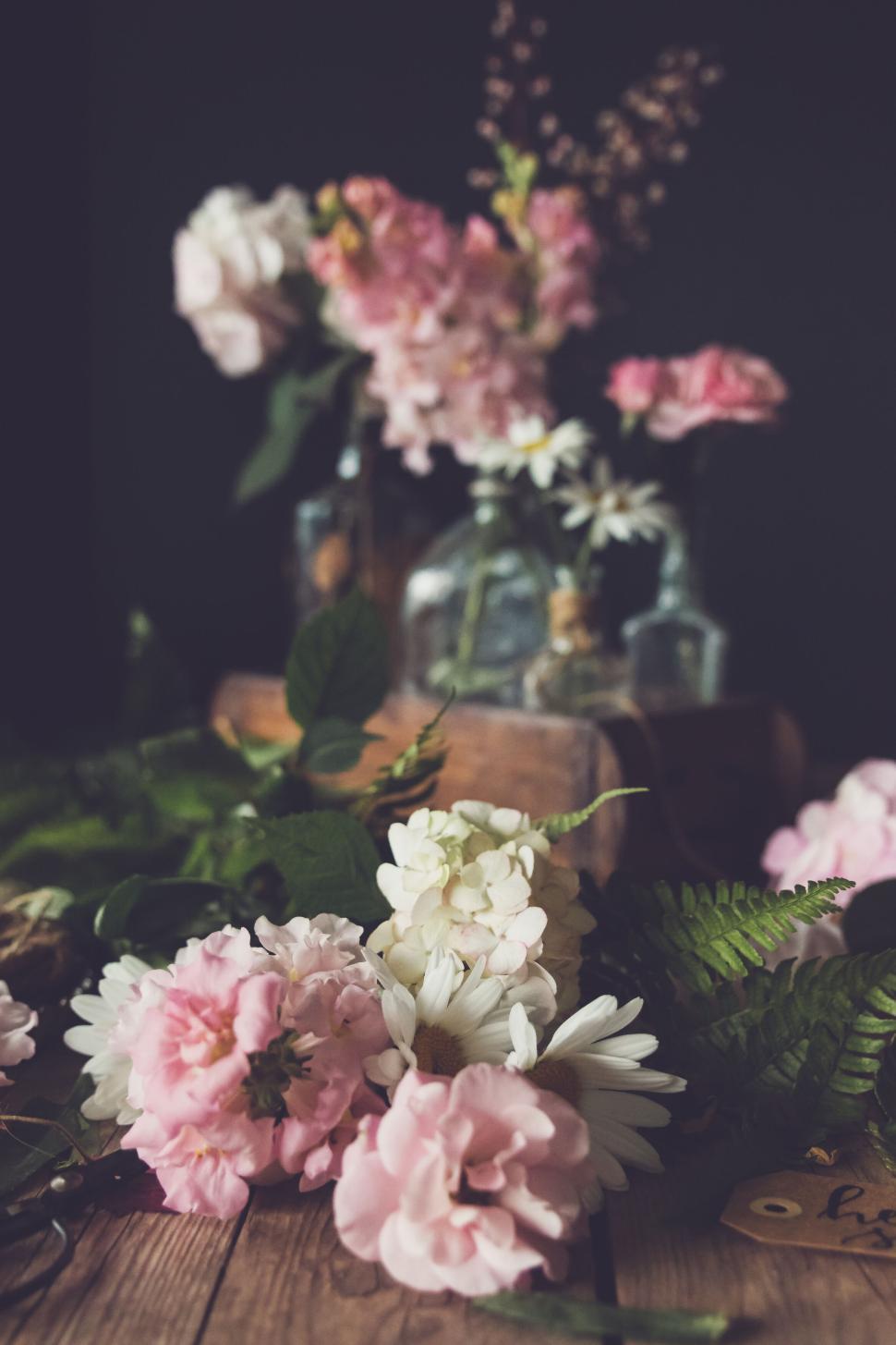 Free Image of Vintage flower arrangement with ferns, daisies, and roses on wooden table. 