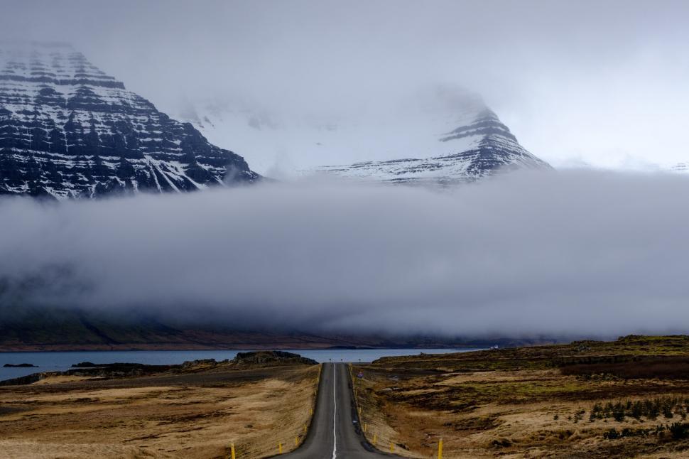 Free Image of Misty mountain road disappearing into the foggy landscape, eerie 